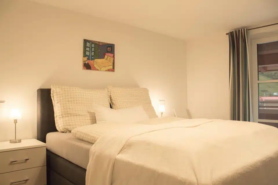 Slaapkamer met bed en schilderij.